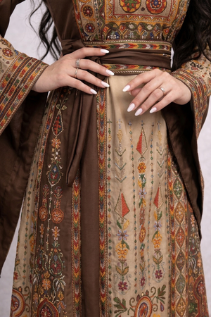 Alhaifawi | Close-up of a person wearing a traditional embroidered garment with intricate patterns.