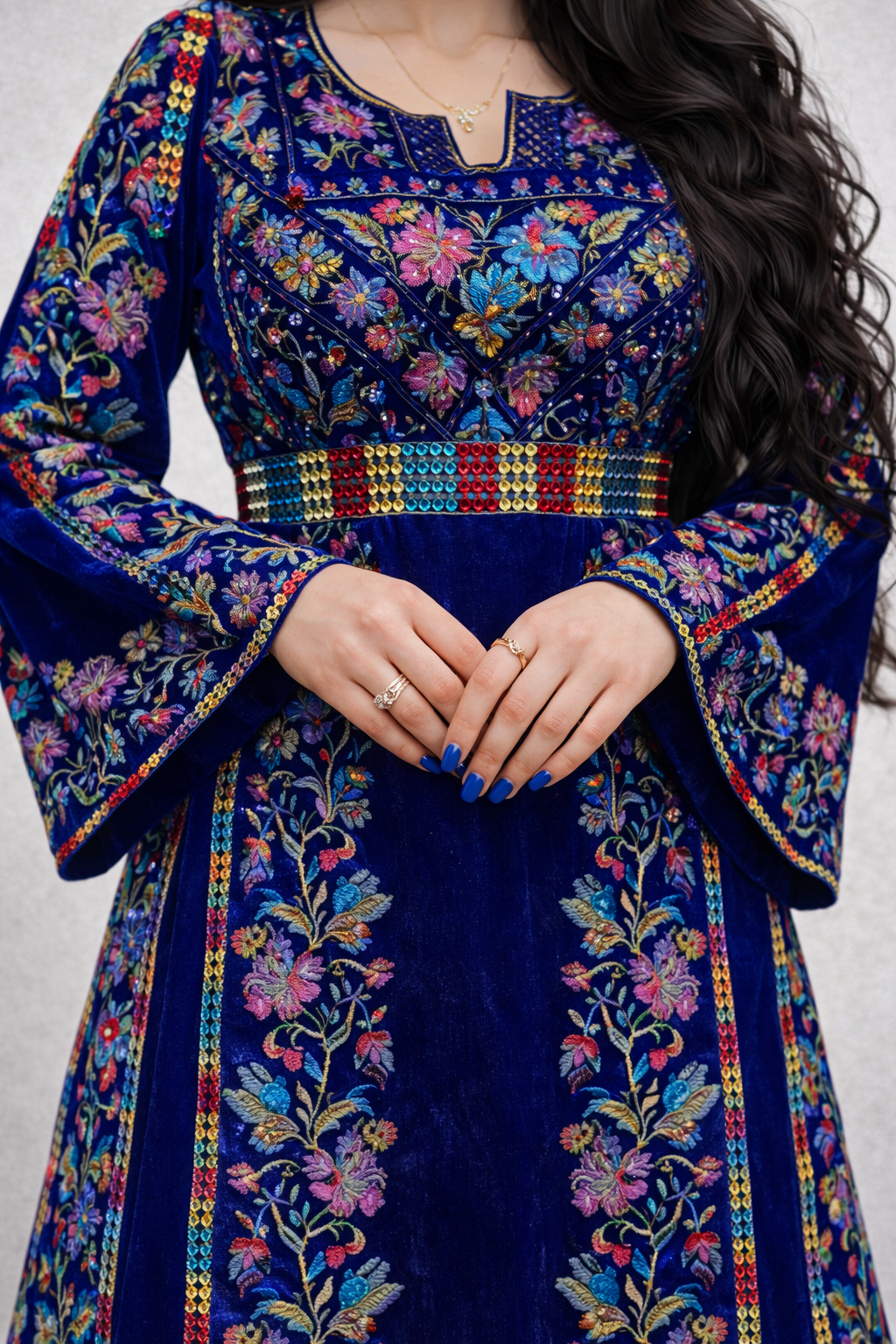 Alhaifawi | Blue embroidered traditional outfit with colorful patterns on a plain background